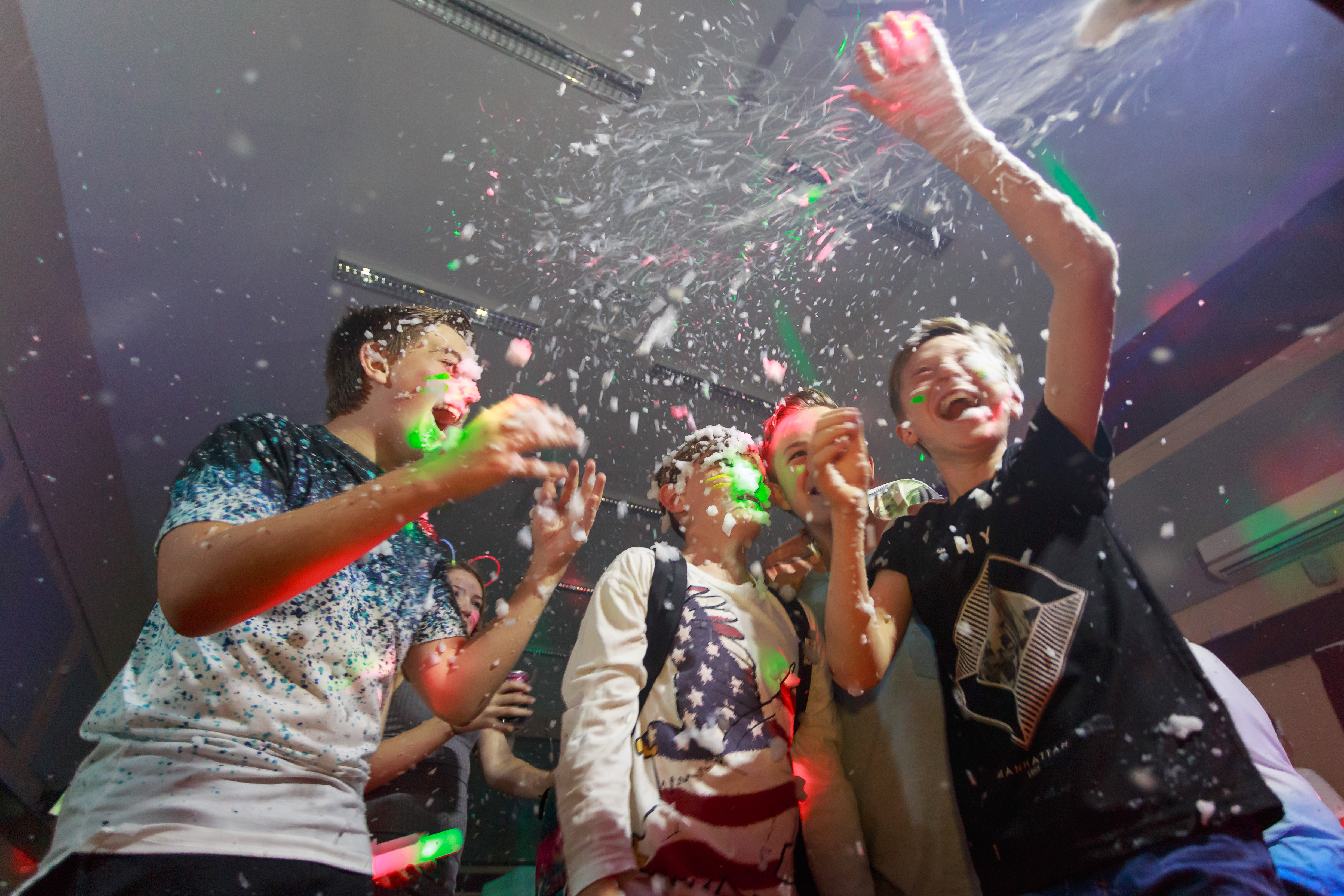 Group of teenage boys having fun with foam at a party