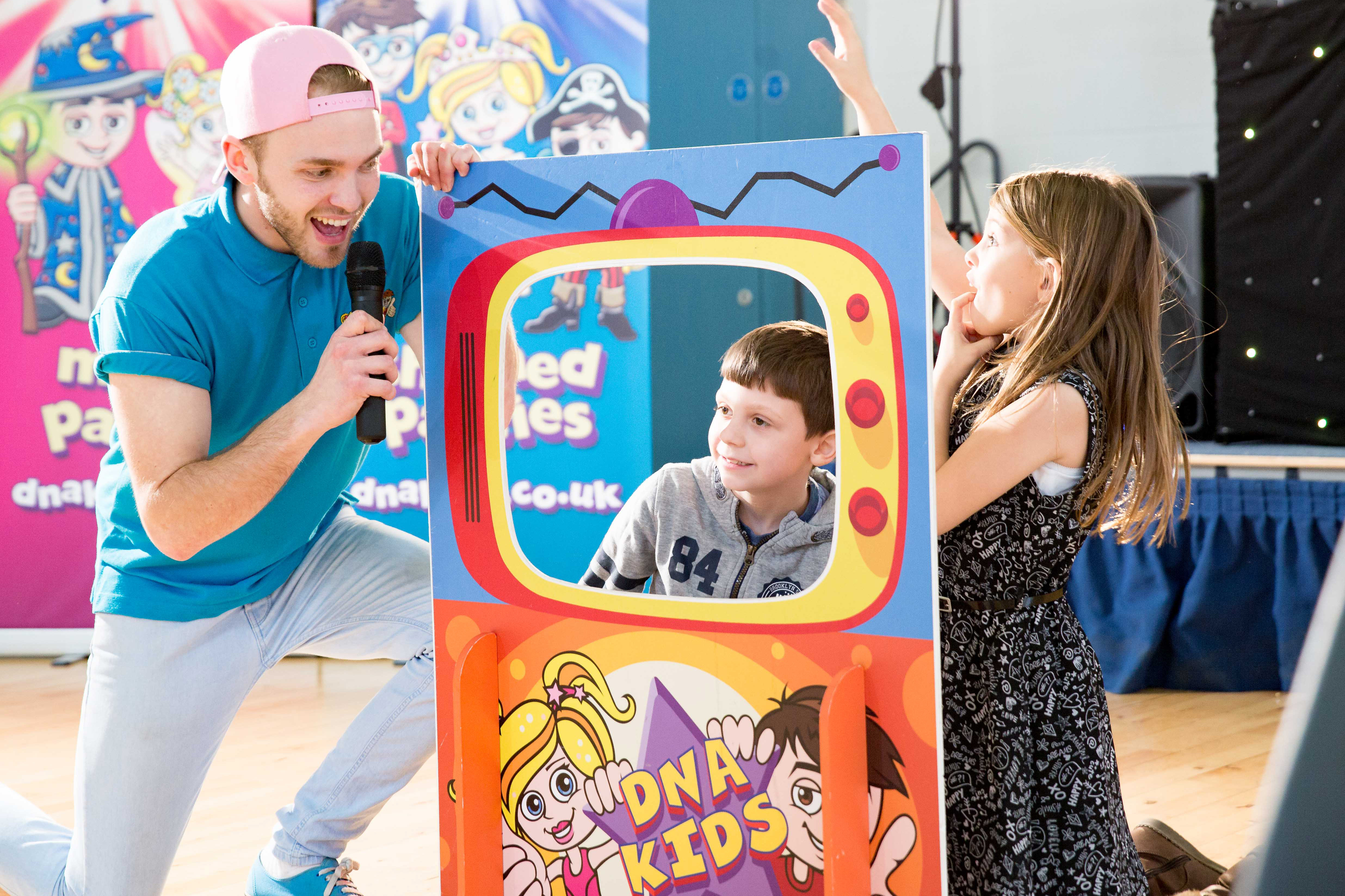 Kids standing behind a cardboard cut-out game