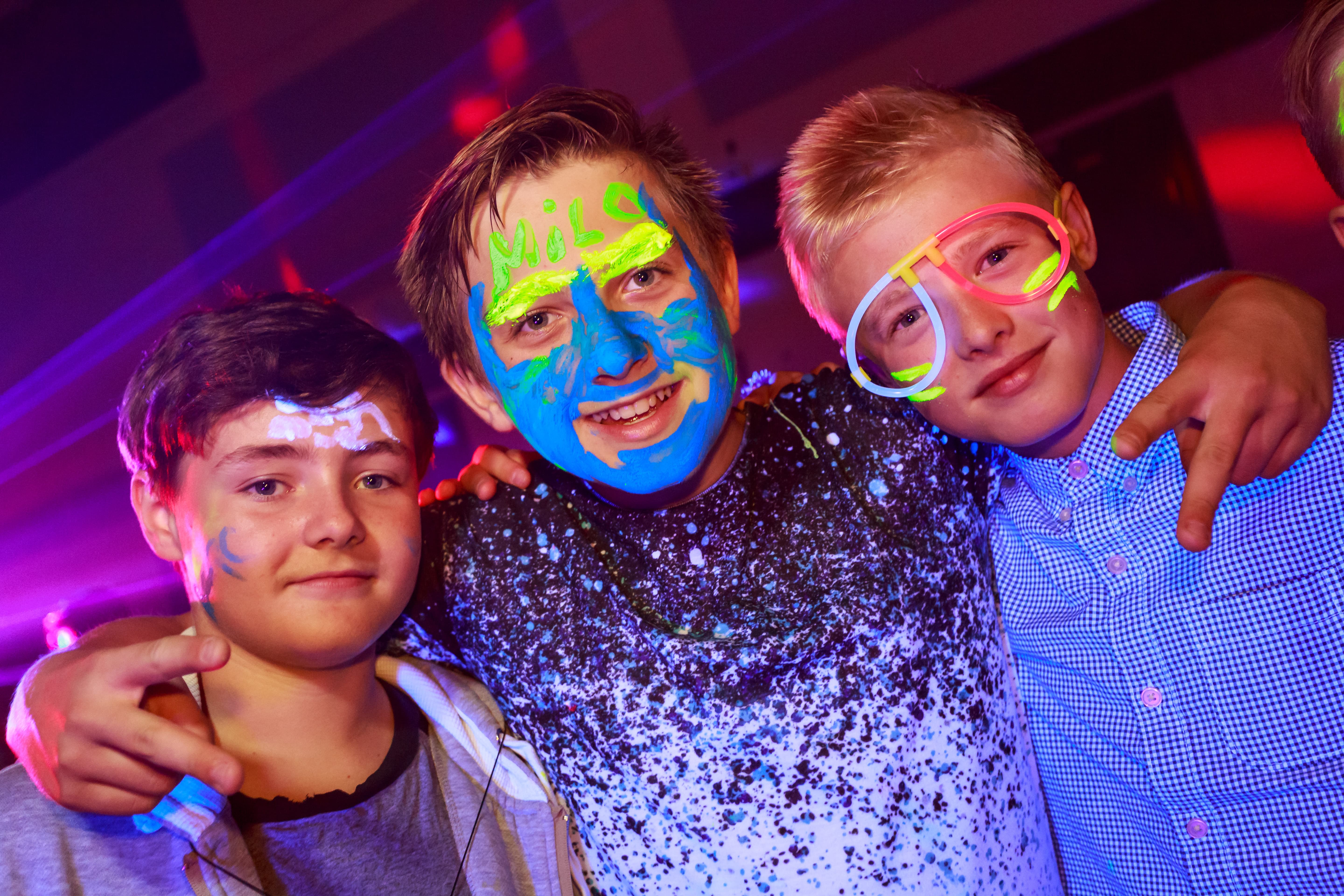 Teenagers at a neon party in a school hall