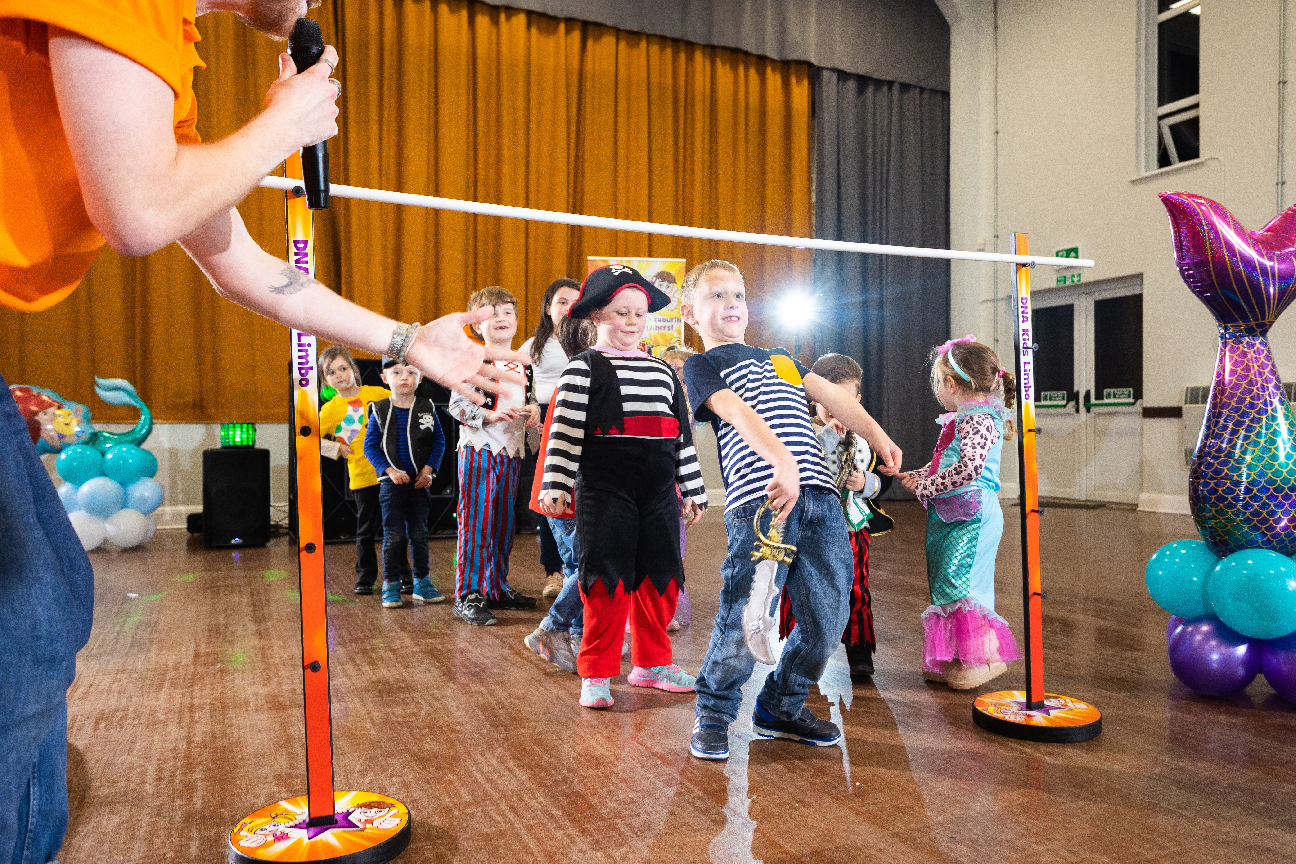 Kids playing limbo at a birthday party