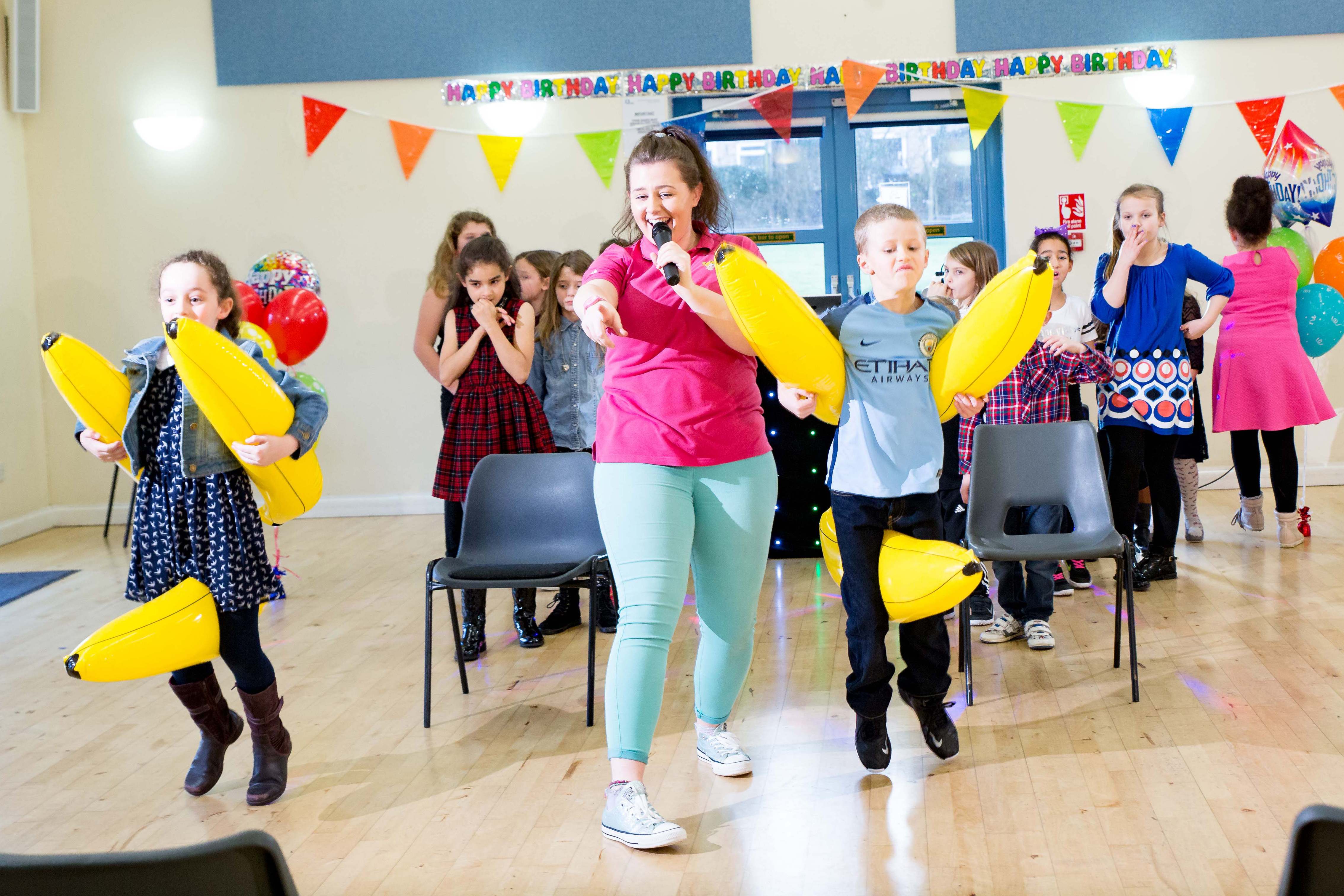 Kids playing a party game with inflatable bananas