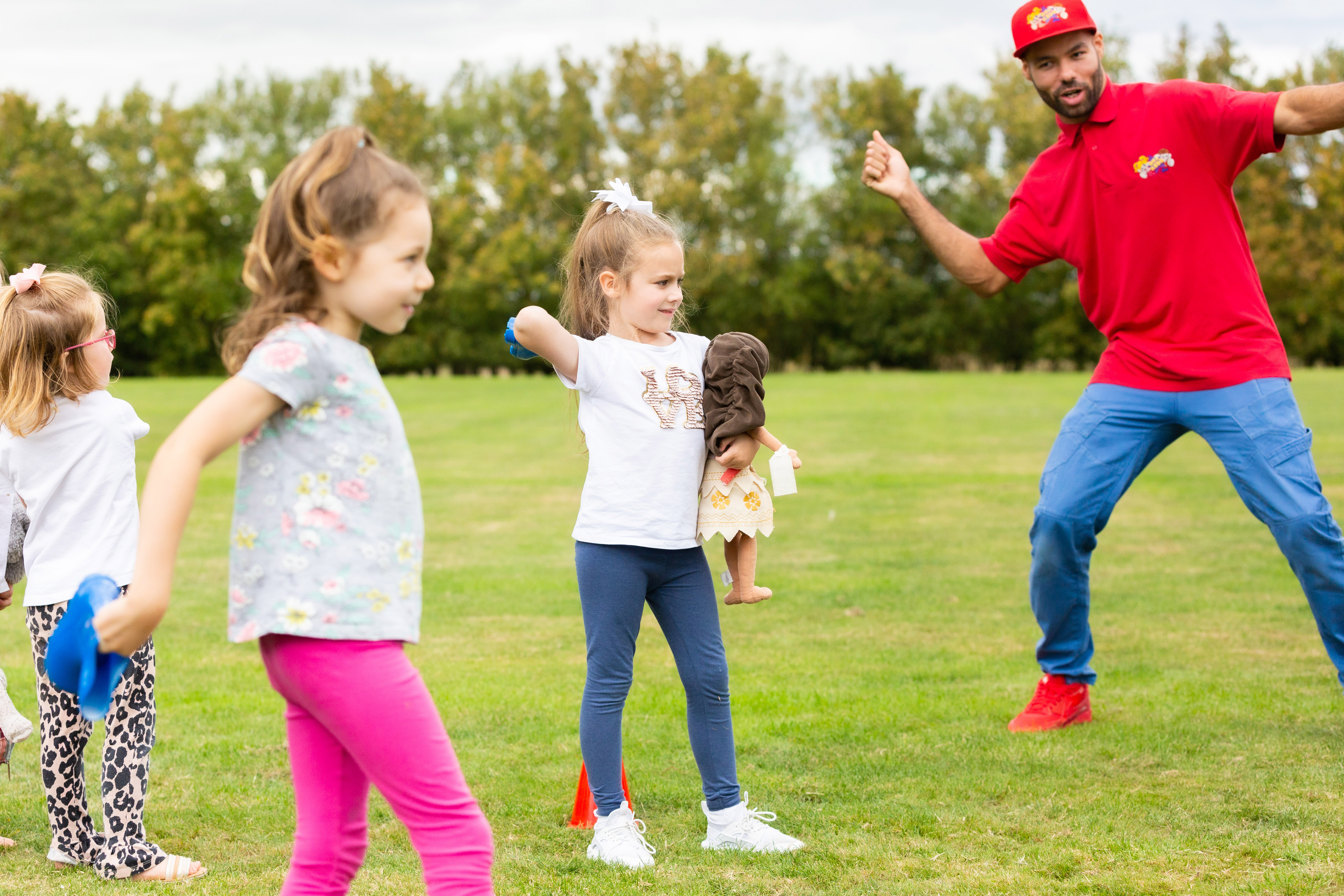 Young children playing outside with a party entertainer